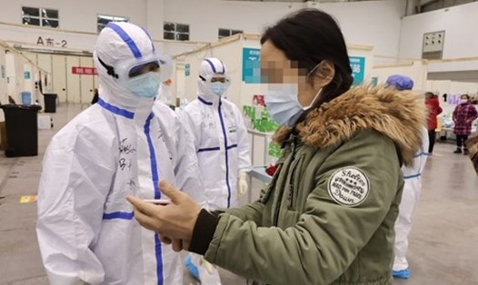 Nhân viên y tế đang trao đổi với bệnh nhân nhiễm COVID-19 tại một bệnh viện dã chiến ở Vũ Hán. Ảnh: Xinhua