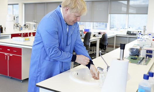 Thủ tướng Anh Boris Johnson rửa tay khi thăm phòng thí nghiệm Mologic, Bedford, Anh. Ảnh: Xinhua.