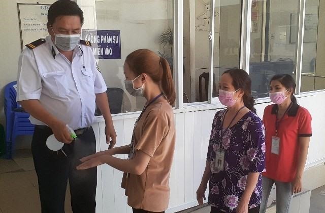 Công nhân được rửa tay, phát khẩu trang trước khi vào xí nghiệp. Ảnh: Nhật Hồ