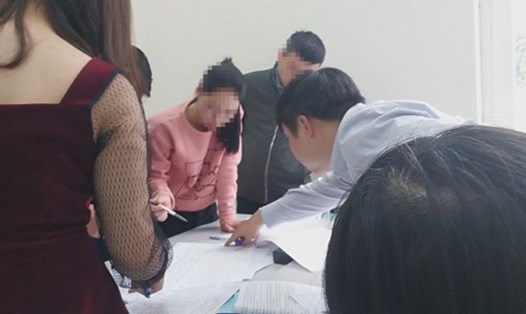 Nhân viên công ty Cổ phần giáo dục Việt Nam hướng dẫn học viên ký khống danh sách điểm danh để đủ điều kiện thi. Ảnh cắt từ clip