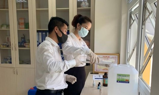 Các nhân viên Cty Điện lực Thừa Thiên Huế tiến hành điều chế dung dịch nước sát khuẩn. Ảnh: ĐP.