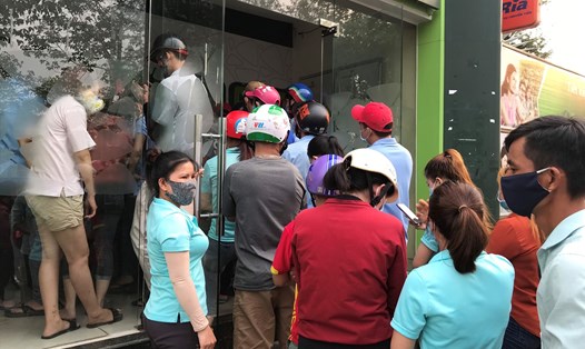 Công nhân chen nhau đứng rút tiền tại thị xã Bến Cát, Bình Dương chiều 10.4. Ảnh: Phạm Diện