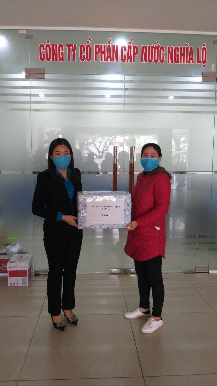 Lãnh đạo LĐLĐ thị xã Nghĩa Lộ (bên trái) tặng khẩu trang, nước rửa tay diệt khuẩn cho CĐCS. Ảnh: Nguyễn Lý