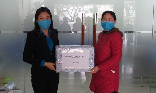 Lãnh đạo LĐLĐ thị xã Nghĩa Lộ (bên trái) tặng khẩu trang, nước rửa tay diệt khuẩn cho CĐCS. Ảnh: Nguyễn Lý
