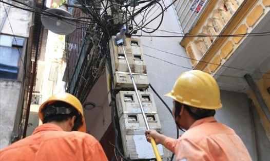 Đo chỉ số côngtơ điện của các hộ dân trên phố Thái Hà, Hà Nội (ảnh chụp trước 1.4.2020). Ảnh: HẢI NGUYỄN
