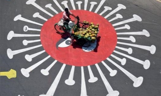 Một người bán dừa đi trên đường phố Ấn Độ hôm 13.4. Ảnh: Reuters.