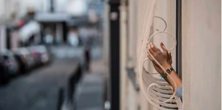 Một công dân Pháp ở Paris đang vỗ tay cổ vũ nhân viên y tế tại ban công căn hộ, ngày 14.4. Ảnh: CNA