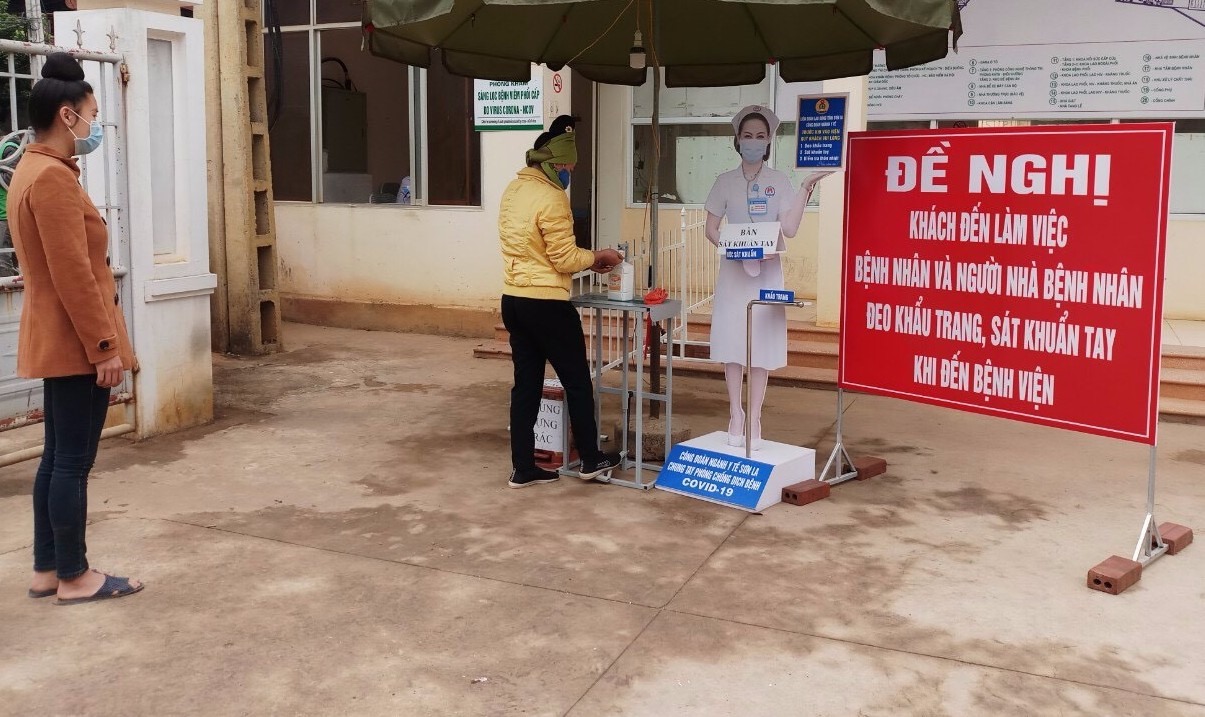 Bệnh nhân sử dụng chân để lấy nước sát khuẩn tay. Ảnh: Lương Thị Chuyển