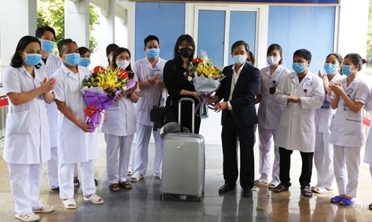 Đại diện lãnh đạo Bệnh viện Đa khoa tỉnh Ninh Bình tặng hoa chúc mừng bệnh nhân 211 được ra viện. Ảnh: NT