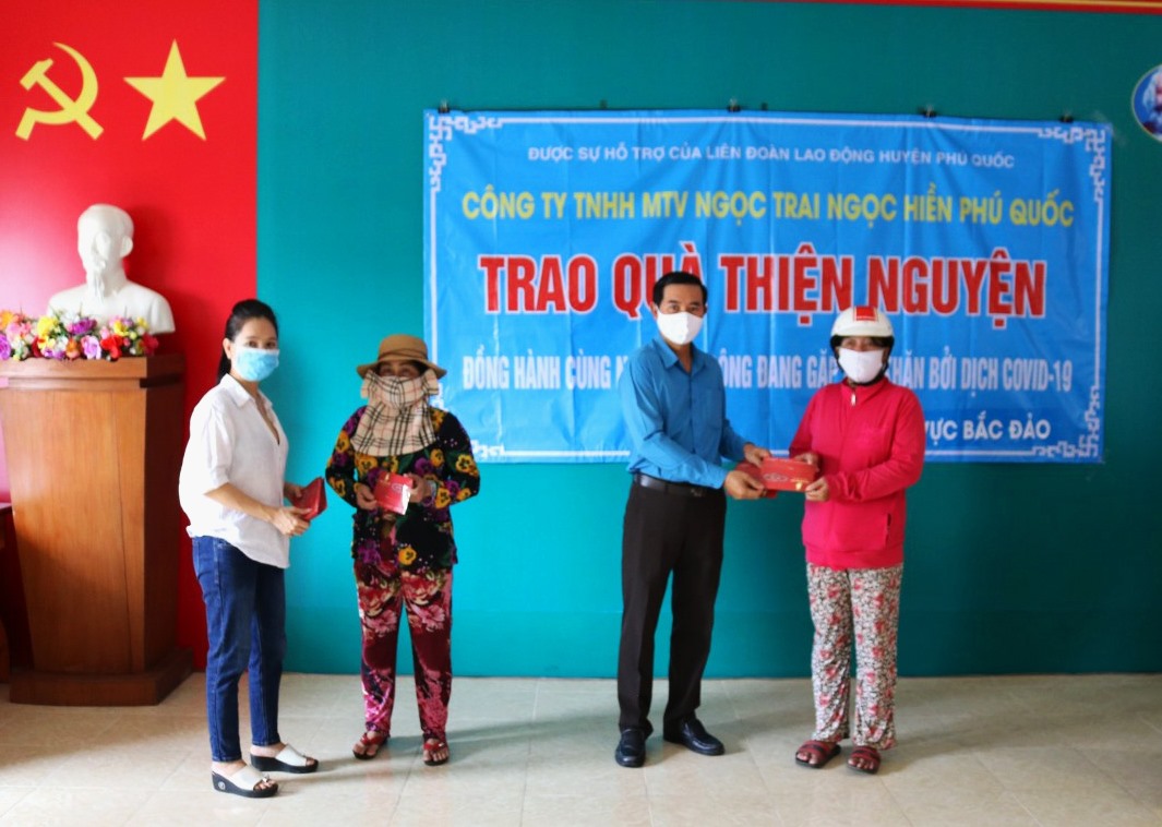 Ông Phan Xuân Trí - Chủ tịch LĐLĐ huyện Phú Quốc tặng quà cho người bán vé số gặp khó khăn do ảnh hưởng dịch COVID-19. Ảnh: Hoàng Xuân