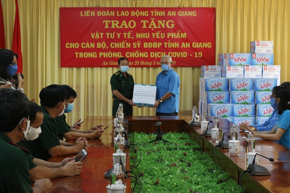 Chủ tịch LĐLĐ tỉnh Nguyễn Thiện Phú trao tặng nước rửa tay sát khuẩn và các nhu yếu phẩm cho lực lượng Bộ đội biên phòng thực hiện nhiệm vụ phòng chống dịch COVID -19. Ảnh Tuyết Như