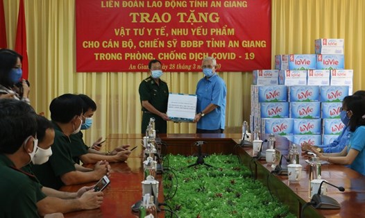 Chủ tịch LĐLĐ tỉnh Nguyễn Thiện Phú trao tặng nước rửa tay sát khuẩn và các nhu yếu phẩm cho lực lượng Bộ đội biên phòng thực hiện nhiệm vụ phòng chống dịch COVID -19. Ảnh Tuyết Như