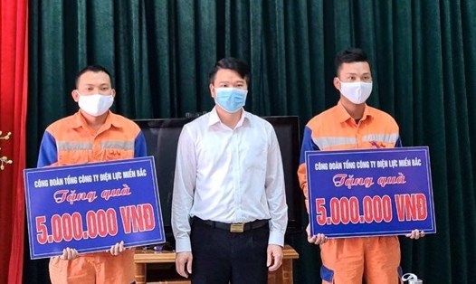 Chủ tịch Công đoàn EVNNPC Trịnh Quang Minh trao khen thưởng và tặng quà cho 2 công nhân Ma Ngọc Khánh, Ma Thế Anh. Ảnh: Tố Vân