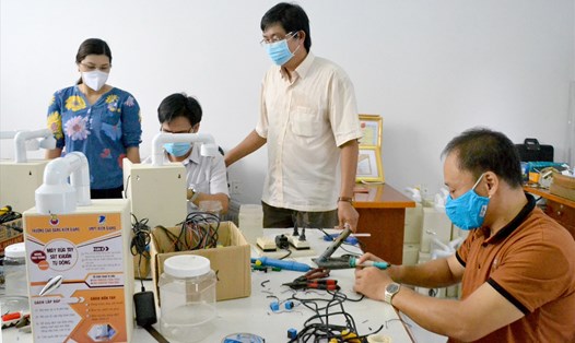Giảng viên Khoa Điện - Điện tử, Trường Cao đẳng Kiên Giang đang nghiên cứu, chế tạo máy rửa tay sát khuẩn tự động. Ảnh: Lục tùng