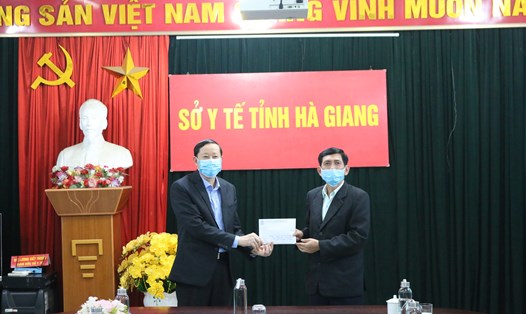Đồng chí Nguyễn Văn Chung - Tỉnh ủy viên, Chủ tịch Liên đoàn Lao động tỉnh Hà Giang (bên phải) trao tiền ủng hộ tới Ban điều hành phòng, chống dịch COVID-19 Sở Y tế Hà Giang.