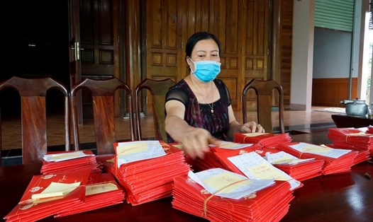 Bà Minh (vợ ông Hùng) cùng hơn 800 thiệp mời gia đình không gửi vì không tổ chức tiệc cưới cho con trai. Ảnh: Quang Đại