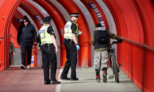 Cảnh sát đang nói chuyện với một người đi xe đạp ở Glasgow, Scotland, Vương Quốc Anh, ngày 31.3. Ảnh: Reuters