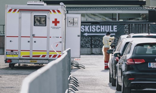 Nhân viên Hội Chữ thập đỏ lấy mẫu bệnh phẩm xét nghiệm COVID-19 tại bãi đỗ xe ở Schuettdorf, Áo, ngày 26.3. Ảnh: AFP