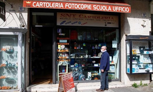 Một người dân trước một cửa hàng ở Catania, Italia, ngày 14.4 khi các cửa hàng được phép mở cửa trở lại. Ảnh: CNN