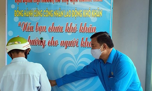 Chủ tịch LĐLĐ tỉnh Cà Mau Võ Thanh Tòng hướng dẫn công nhân nhận gạo tại cây “ATM gạo”. Ảnh: Nhật Hồ