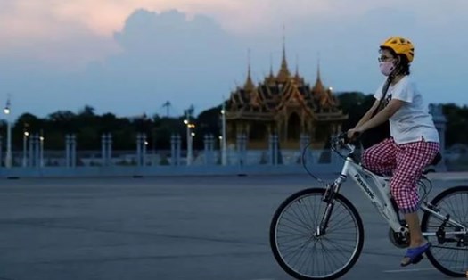 Một phụ nữ đạp xe trên đường phố Bangkok, Thái Lan, ngày 19.4. Ảnh: RT