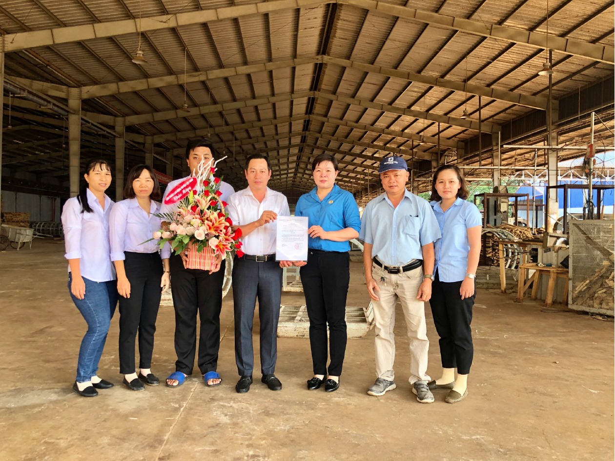 Bà Đinh Thị Mỹ Hạnh-Chủ tịch LĐLĐ huyện trao quyết định thành lập và tặng hoa chúc mừng BCH CĐCS Công ty CP Gỗ Lộc Ninh. Ảnh Ngọc Huy