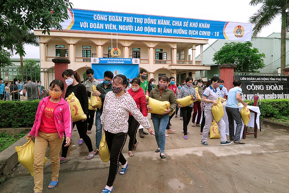 Công nhân lao động khó khăn hồ hởi nhận gạo miễn phí do LĐLĐ tỉnh Phú Thọ trao tặng. Ảnh: Mai Hoa
