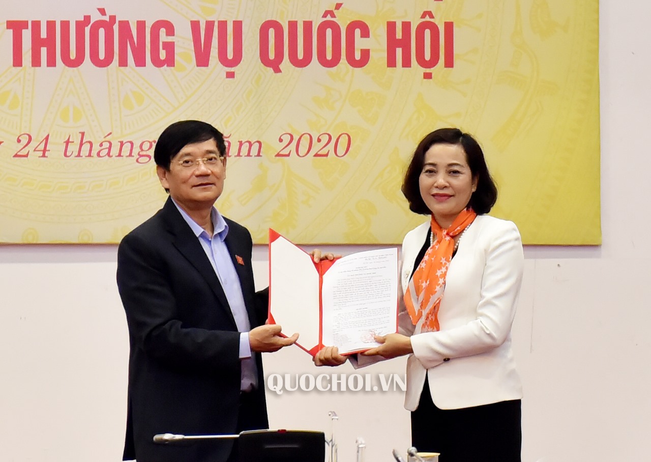 Thay mặt Ủy ban Thường vụ Quốc hội, Trưởng ban Công tác đại biểu Trần Văn Túy trao Nghị quyết của Ủy ban Thường vụ Quốc hội cho bà Nguyễn Thị Thanh. Ảnh Quochoi.vn