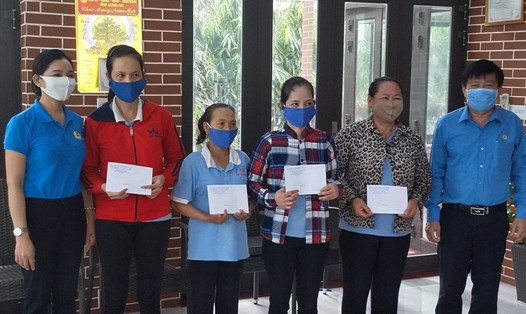 Chủ tịch LĐLĐ tỉnh Long An Nguyễn Văn Quí (phải ảnh) tặng quà cho công nhân lao động khó khăn. Ảnh: Kỳ Quan