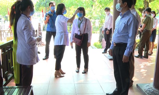 Nhân viên y tế tại Khu du lịch sinh thái Tràng An tiến hành kiểm tra sức khỏe và đo thân nhiệt đối với khách tham quan và nhân viên phục vụ. Ảnh: NT