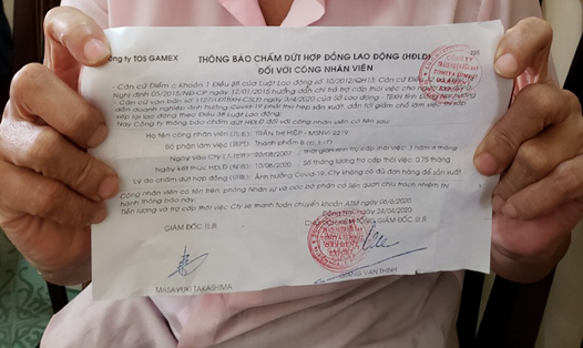 Bà Trần Thị Hiệp, 50 tuổi, công nhân Công ty TNHH Tomiya Summit Garment Export với mảnh giấy thông báo chấm dứt hợp đồng lao động trên tay. Ảnh: Hà Anh Chiến