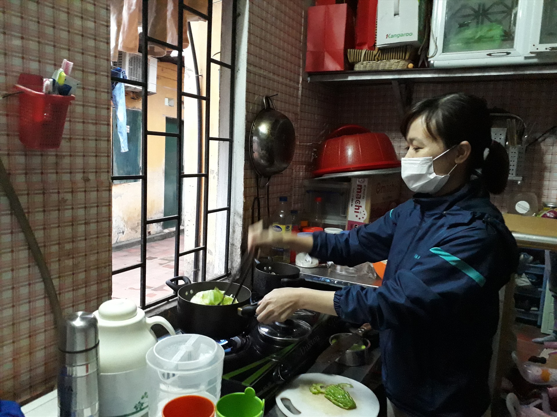 Nhiều công nhân lựa chọn ở lại phòng trọ trong dịp nghỉ lễ 30.4 này. Trong ảnh: Một nữ công nhân đang nấu ăn cho gia đình mình tại phòng trọ. Ảnh: Quế Chi
