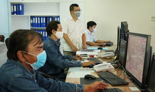 Ông Nguyễn Văn Thanh (người đứng), Phó Tổng Giám đốc EVNHCMC, đang kiểm tra việc trực vận hành tại Cty Điện lực Sài Gòn sáng 2.4. Ảnh Việt Anh