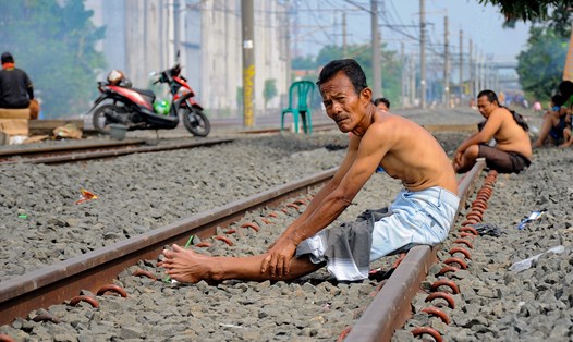 Người dân Indonesia đổ xô đến các đường ray tàu hỏa để tắm nắng với hy vọng ngăn ngừa dịch COVID-19. Ảnh: AFP