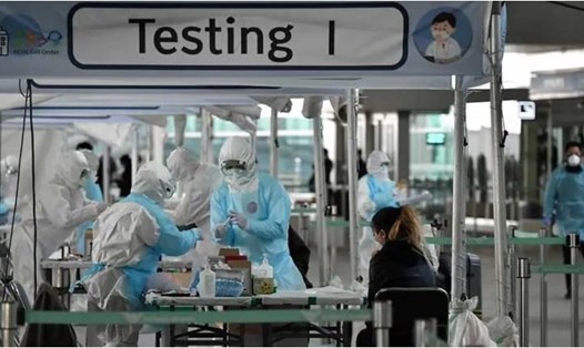 Nhân viên y tế đang lấy mẫu xét nghiệm 1 du khách nước ngoài ở sân bay Incheon, Seoul, Hàn Quốc. Ảnh: AFP