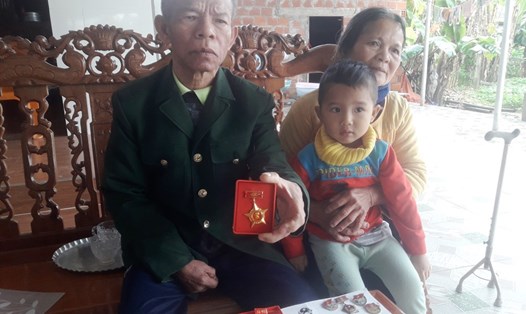 Vợ chồng cựu binh Nguyễn Huy Hiển bên đứa cháu nhỏ. Ảnh: Trần Tuấn