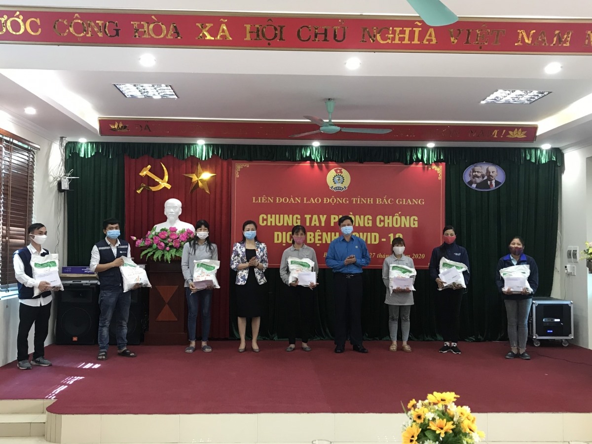 Đồng chí Lê Thị Thu Hồng, Phó Bí thư Thường trực Tỉnh ủy, Trưởng Đoàn đại biểu Quốc hội tỉnh và đồng chí Nguyễn Văn Cảnh, Chủ tịch Liên đoàn Lao động tỉnh tặng gạo cho CNLĐ có hoàn cảnh khó khăn. Ảnh: Mai Liên.