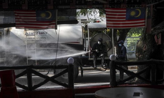 Các quan chức y tế khử trùng đường phố quanh nhà thờ Hồi giáo Sri Petaling ở Kuala Lumpur. Ảnh: EPA-EFE.