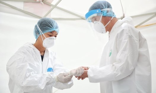 Cán bộ y tế bảo hộ trước khi lấy mẫu xét nghiệm COVID-19. Ảnh: Hải Nguyễn