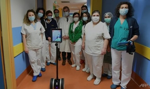 Các bác sĩ chụp cùng Robot, trợ lý đồng hành đắc lực giúp họ chăm sóc các bệnh nhân đặc biệt và giảm nguy cơ lây nhiễm trong bệnh ở Varese, phía bắc Italia. Ảnh: AFP