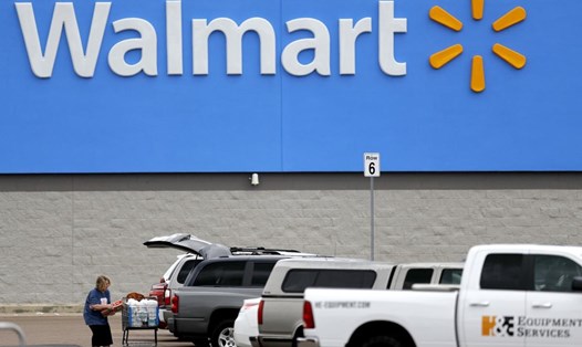 Một phụ nữ chất hàng lên xe tại một siêu thị Walmart ở Pearl, bang Mississippi, Mỹ, ngày 31.3. Ảnh: AP
