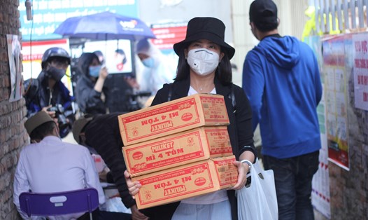 Chị Nguyễn Phương Hoa cùng khuân vác những thùng mì tôm hỗ trợ các bệnh nhân xóm chạy thận. Ảnh: Vương Đông