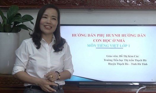 Cô Kim Cúc hướng dẫn phụ huynh học sinh lớp 1 ôn tập. Ảnh: PV