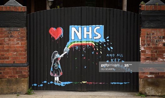 Bức tranh vẽ lại logo của Dịch vụ Y tế quốc gia Anh (NHS) và cầu vồng, trong tình yêu tuôn tràn với thông điệp cảm ơn nhân viên NHS và các nhân viên chủ chốt điều trị bệnh nhân COVID-19, ở Pontefract, miền Bắc nước Anh. Ảnh: Getty