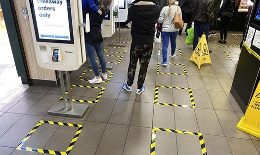 Người dân thực hiện giữ "khoảng cách xã hội" khi xếp hàng tại trung tâm mua sắm Brent Cross ở London, Anh. Ảnh: REUTERS/Paul Childs.
