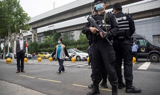 Một sĩ quan cảnh sát đứng gác tại cổng trường học ở Vũ Hán, Trung Quốc. Ảnh: AFP.