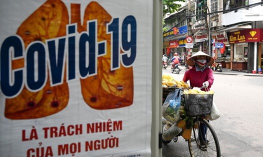 Ápphích tuyên truyền ngăn chặn COVID-19 được dán ở khu phố cổ của Hà Nội, Việt Nam. Ảnh: AFP.
