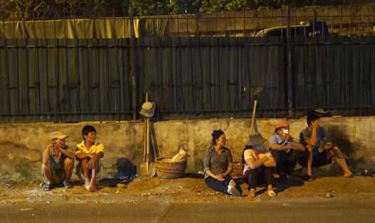 Người lao động ngồi đợi việc mòn mỏi bên lề đường tại Hà Nội. Ảnh: Trần Kiều
