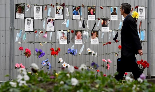 Một người dân đi ngang qua khu vực tưởng niệm tạm thời dành cho các nhân viên y tế đã chết vì COVID-19 bên ngoài 1 cơ sở y tế địa phương ở Saint Petersburg, Nga hôm 11.5. Ảnh: AFP.