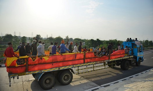 Công nhân Ấn Độ ở ngoại ô Allahabad đi trên một chiếc xe tải trở về quê nhà hôm 12.5 sau khi chính phủ nới lỏng hạn chế chống dịch COVID-19. Ảnh: AFP.